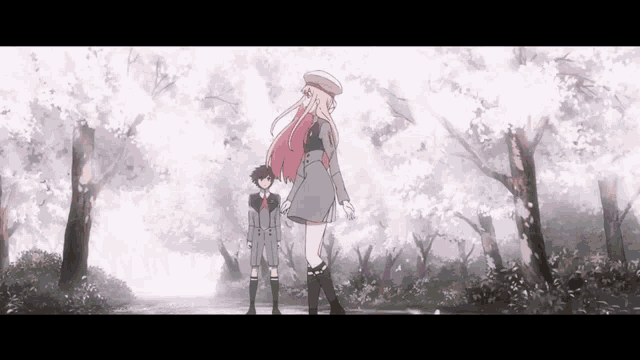 a boy and a girl are standing next to each other in a forest with cherry blossoms .