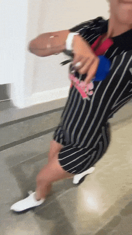 a person wearing a black and white striped dress is holding a purse that says ' disney ' on it