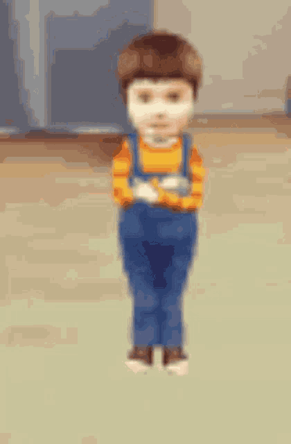 a blurry picture of a boy in overalls and a yellow shirt