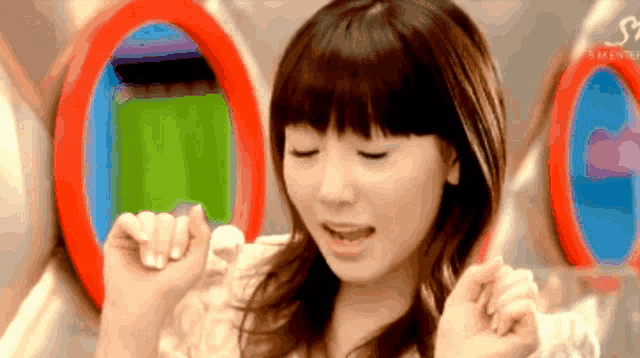 a girl with her eyes closed stands in front of a circle with the letter s on it