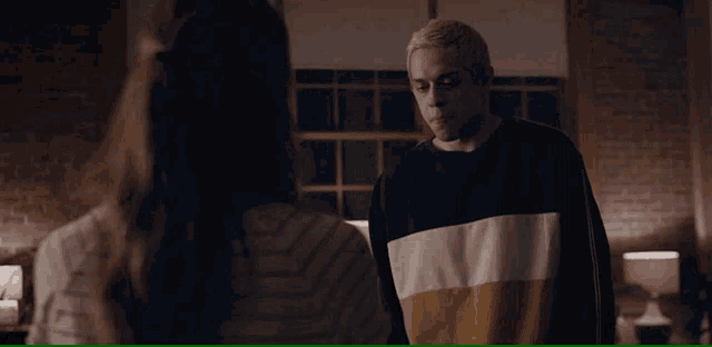 a man and a woman are looking at each other in a dark room