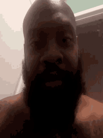 a man with a beard and a tattoo on his arm looks down