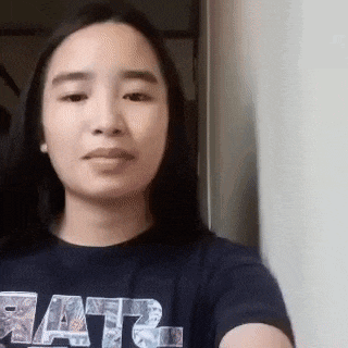 a woman wearing a star wars shirt is taking a selfie with her phone .