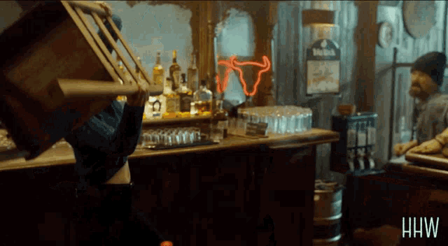 a man is carrying a chair in a bar with a sign that says heineken