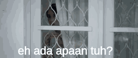 a woman is looking out of a window with the words `` eh ada apaan tuh '' .