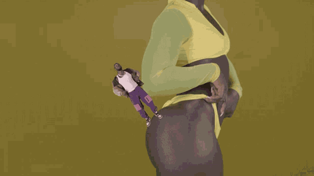 a woman in a yellow top and purple pants is holding a small man