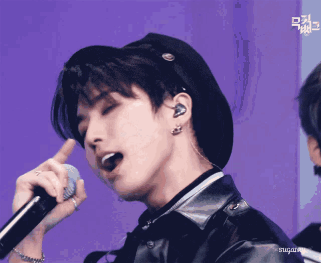 a close up of a person singing into a microphone with the name sugary on the bottom