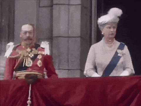 a man in a red uniform is standing next to a woman in a white hat .