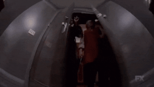 a man and woman are holding guns in a dark room .