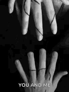 a black and white photo of two hands holding each other with the words `` you and me '' written below them .