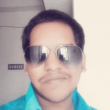 a young man is wearing sunglasses and a blue shirt .