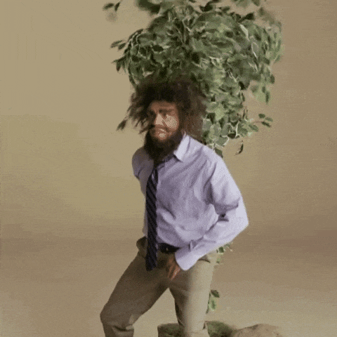 a man with a beard and tie is holding a tree in front of his head