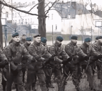 a group of soldiers are marching in a line with guns