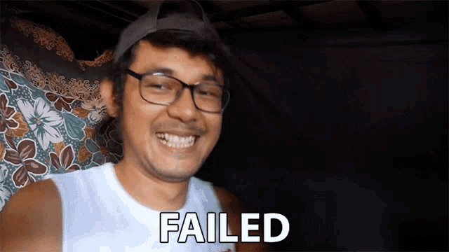 a man wearing glasses and a hat is smiling with the word failed below him