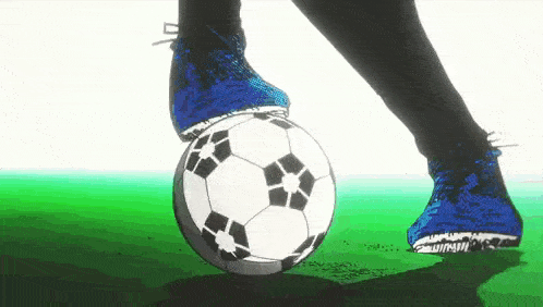 a person wearing blue shoes is kicking a soccer ball .