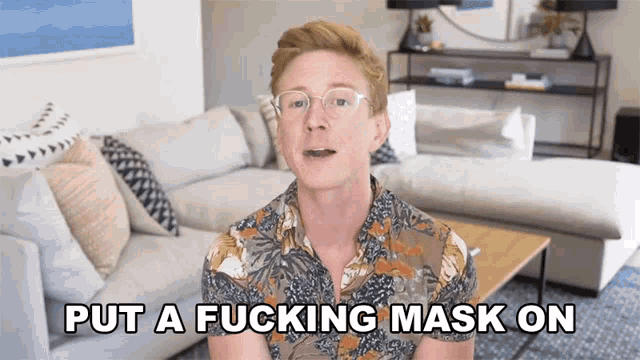 a man wearing glasses says put a fucking mask on in a living room