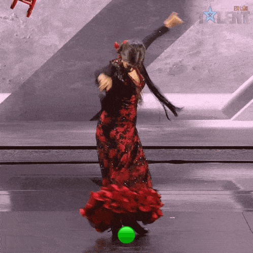 a woman in a red dress is dancing in front of a sign that says ' talent '