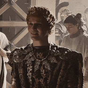 a man with a crown on his head is smiling in front of a group of people