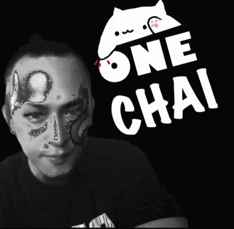 a man with a tattoo on his face is wearing a one chai shirt