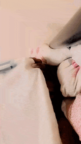 a close up of a person 's feet on a bed with a white blanket