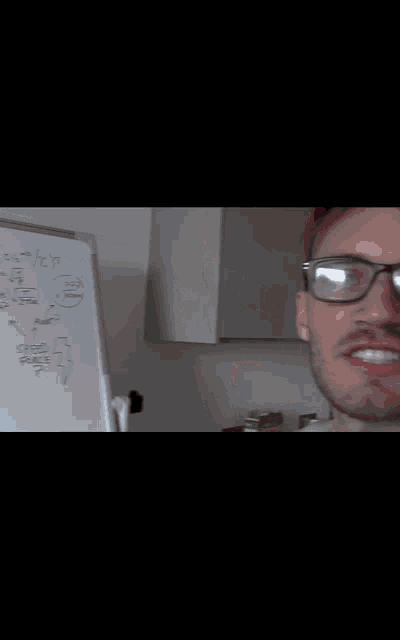 a man wearing a red hat is writing on a whiteboard