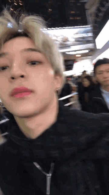 a close up of a man 's face in a crowded area