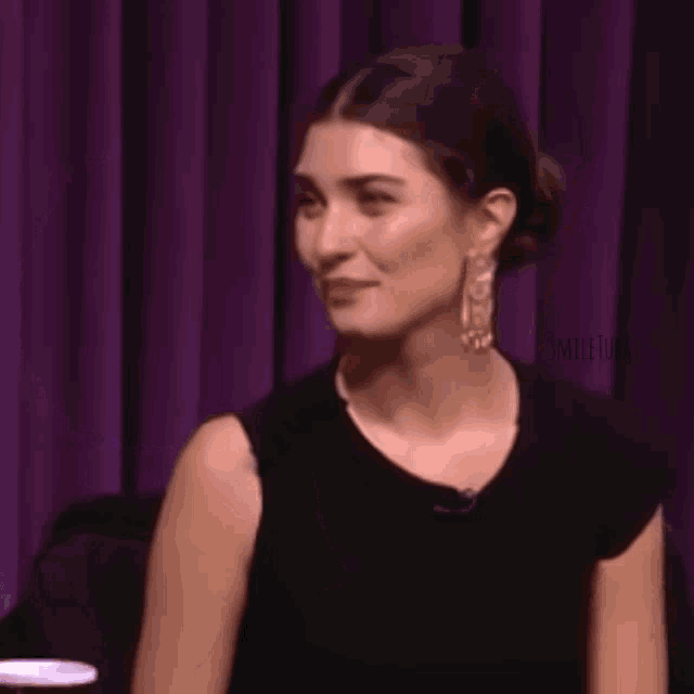 a woman is holding a purple circle with the word evet written on it .