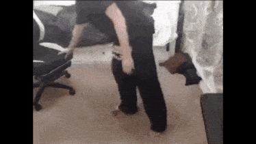 a person is standing on a carpeted floor in a room with a chair in the background .