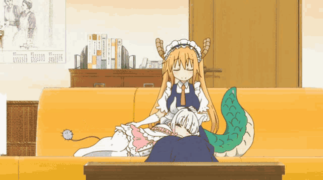 a couple of anime characters laying on a couch with a calendar on the wall behind them
