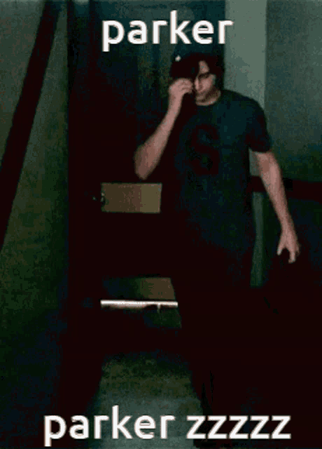 a man wearing a black shirt with the letter s on it wipes his nose