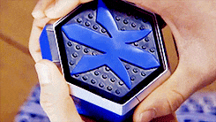 a person is holding a blue box with an x on it in their hands