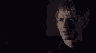 a close up of a man 's face in the dark with a blurred background .