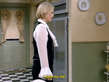 a woman is standing in front of a refrigerator and saying i hate my life