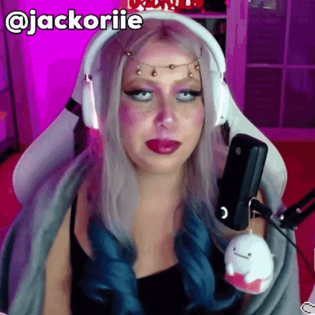 a woman wearing headphones is sitting in front of a microphone with the name jackorie written on the bottom
