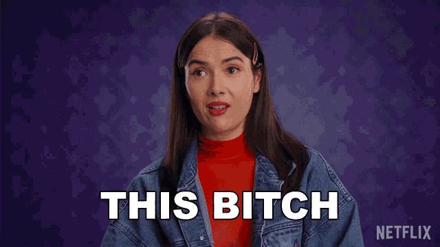 a woman in a red turtleneck and denim jacket says " this bitch "