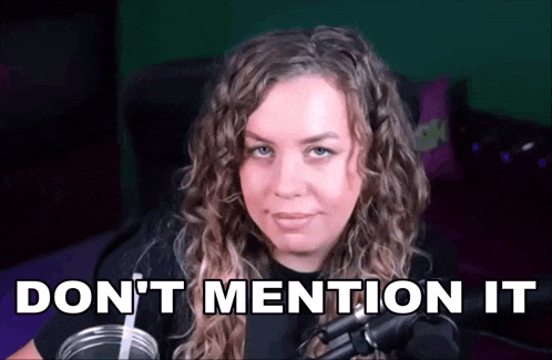 a woman with curly hair is sitting in front of a microphone with the words " do n't mention it " written above her