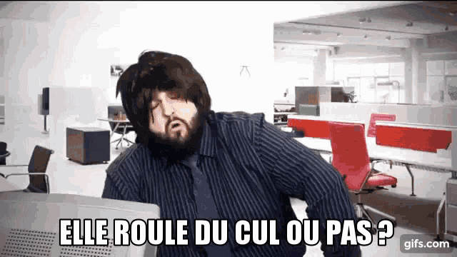 a man with a beard is sitting in front of a computer with the words elle roule du cul ou pas