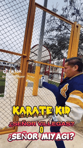 a man in a blue jacket is kicking a chain link fence with the caption karate kid
