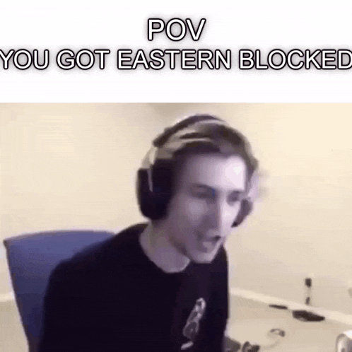 a man wearing headphones is sitting at a desk with his mouth open .