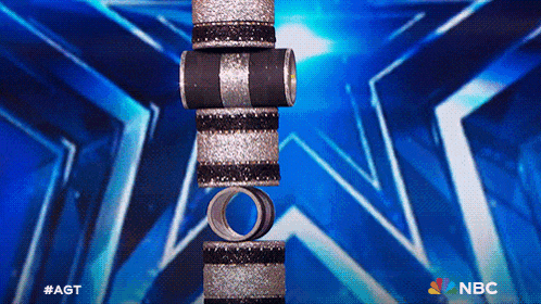 a stack of silver and black rings against a blue background with the nbc logo