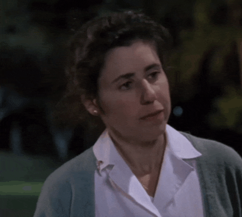 a woman wearing a white shirt and a green cardigan