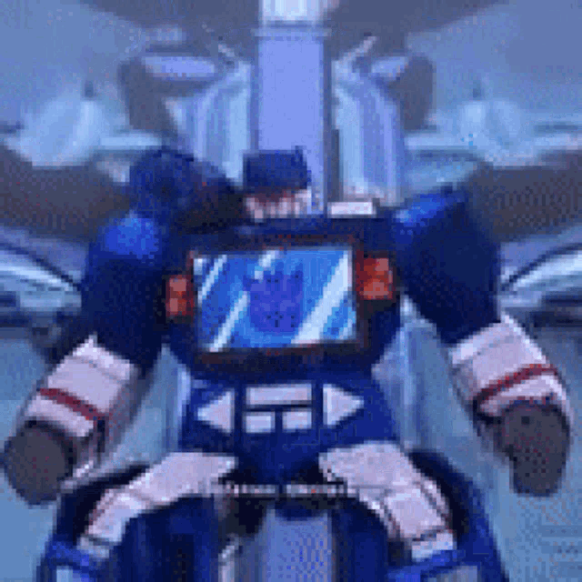 a blue robot with a screen on its chest is sitting on a chair .