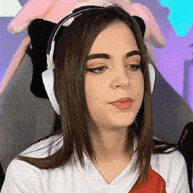 a woman wearing headphones and a cat ear headband is sitting in a chair .
