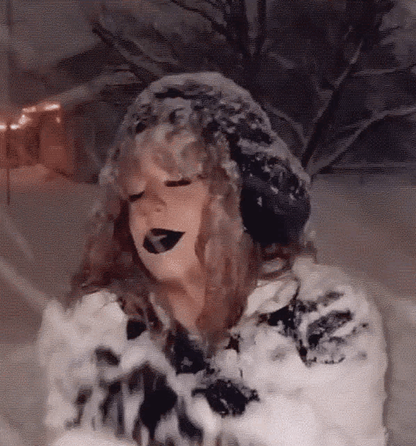 a woman wearing black lipstick and a fur hat is standing in the snow