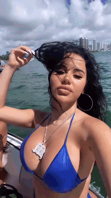 a woman in a blue bikini is on a boat in the ocean