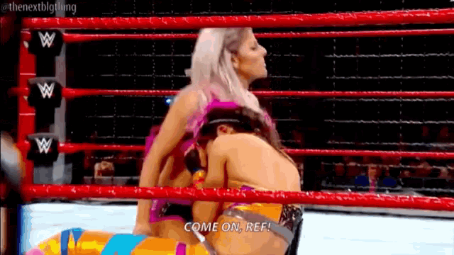 two women are wrestling in a wrestling ring and one of them says come on ref .