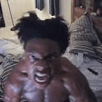 a shirtless man is laying on a bed with his mouth open and a very angry look on his face .