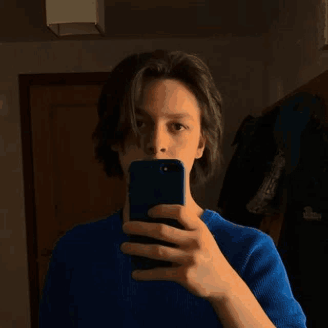 a young man is taking a selfie with his cell phone .