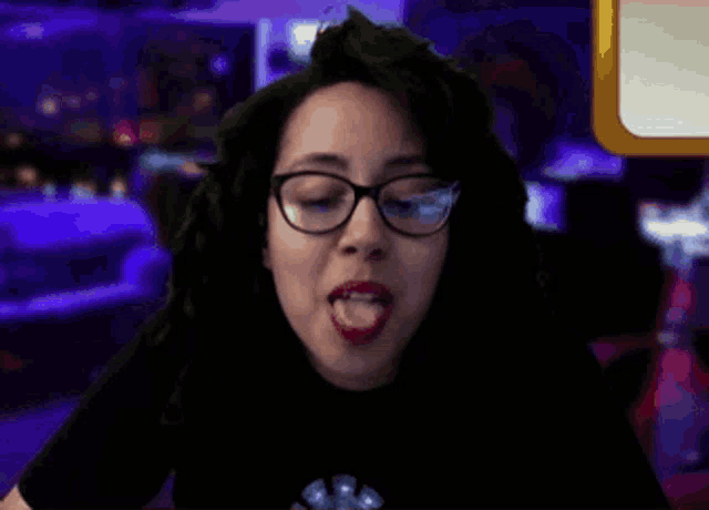 a woman with glasses and red lipstick is eating something