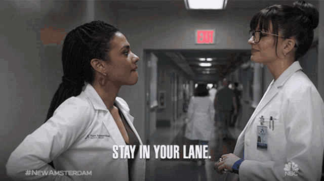 two female doctors talking in a hallway with the words stay in your lane written on the bottom